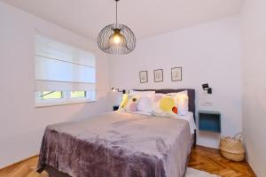 a bedroom with a bed and a pendant light at DAIROS2 in Mali Lošinj