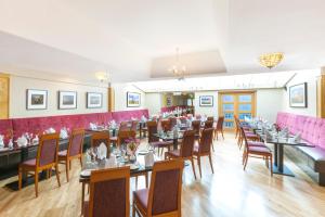 una sala da pranzo con tavoli, sedie e pareti rosa di Ring of Kerry Hotel a Cahersiveen
