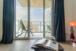 um quarto com uma mesa com um livro e uma varanda em Haus-Seeblick-in-Bosau-Wohnung-3 em Bosau
