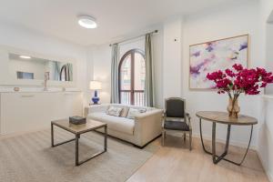 salon z kanapą i stołem z kwiatami w obiekcie Green-Apartments Pleno Centro w Sewilli +149 zdjęć