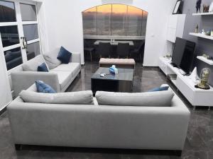 a living room with two couches and a television at Big Seafront Apartment in Saida Lebanon in Saïda