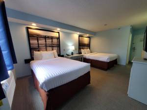 een hotelkamer met 2 bedden in een kamer bij Coastal Inn & Suites in Wilmington