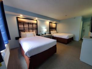 Кровать или кровати в номере Coastal Inn & Suites