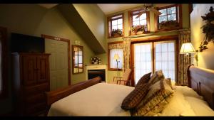 a bedroom with a bed and a fireplace and windows at WeatherPine Inn in Niagara on the Lake