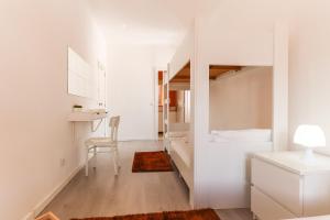 Camera bianca con letto, scrivania e sedia. di Downtown Lisbon Palma Suites by Hosty a Lisbona
