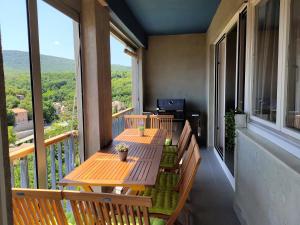 a balcony with wooden tables and benches on a balcony at Apartman Borna in Vrbnik