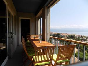 porche con mesa de madera y sillas en el balcón en Apartman Borna en Vrbnik