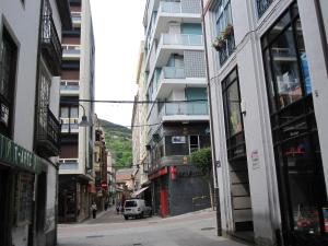 a city street with buildings and a car on a street at Casa Baratura in Cangas del Narcea
