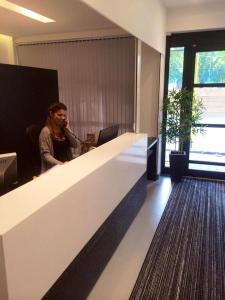 un homme assis à un bureau dans un bureau dans l'établissement Pelican London Hotel and Residence, à Londres