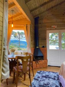 une salle à manger avec une table et une cheminée dans l'établissement Estalagem Villa Serrana, à Urubici