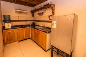 a kitchen with wooden cabinets and a stainless steel refrigerator at Hotel Parina Atacama in San Pedro de Atacama