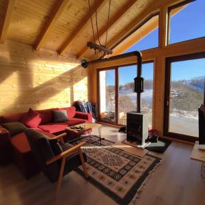 a living room with a red couch and large windows at Villa Grashtica - Prishtina City in Pristina +32 photos