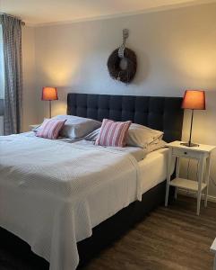 ein Schlafzimmer mit einem großen Bett mit zwei Lampen in der Unterkunft Friesen-Lodge Ferienwohnungen in Breklum