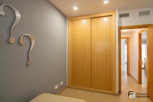 a bedroom with a wooden door and a mirror at Apartamento Residencial Mirador Playa Serena in Roquetas de Mar +24 photos