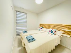 Dos camas en una habitación blanca con toallas. en Ground flor apartament in Turquesa del Mar, Playa Flamenca, en Orihuela