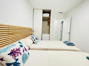 Dos camas en una habitación con paredes blancas. en Ground flor apartament in Turquesa del Mar, Playa Flamenca, en Orihuela