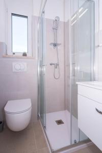 y baño con ducha, aseo y lavamanos. en The Blueview Appartements Novigrad en Novigrad Istria