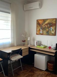 una habitación con 2 escritorios, una mesa y una pintura en ZEN Home en Tandil