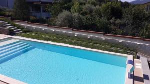 a large blue swimming pool in front of a house at Di Luna e Di Sole in Sarzana