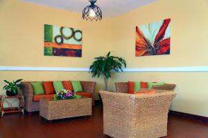 a living room with two couches and a plant at Hotel Jaragua in Veracruz