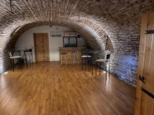 a large room with a brick wall and wooden floors at LE GOLURET Chambres & Table d'hôtes - Espace Bien Être in Couvignon