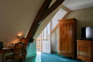 a room with a staircase with a tv and a door at Le Clos De Bourgogne in Moulins