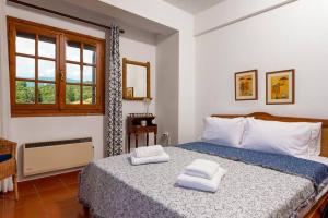 1 dormitorio con 1 cama con 2 toallas en Seaside House with view over Pagasitikos, en Áfissos