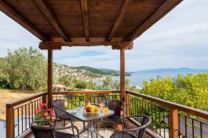una mesa y sillas en un balcón con vistas al océano en Seaside House with view over Pagasitikos, en Áfissos