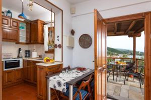 eine Küche mit einem Tisch und einem Balkon in der Unterkunft Seaside House with view over Pagasitikos in Áfissos