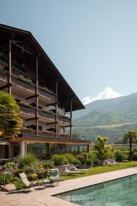 un complexe avec une piscine et des montagnes en arrière-plan dans l'établissement Hotel Salgart, à Merano