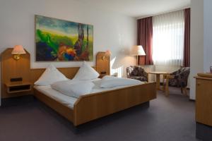 ein Hotelzimmer mit einem Bett in einem Zimmer in der Unterkunft Hotel Gasthof Zum Storch in Schlüsselfeld