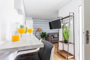 a living room with two glasses of orange juice on a counter at Green-Apartments San Francisco in Seville