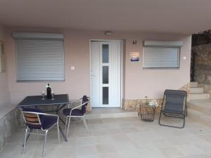 a patio with chairs and a table and a door at Apartments Julia & Nika in Karlobag