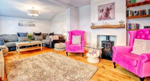 a living room with pink furniture and a fireplace at Norfolk Holiday Cottage 4-Bed Luxury Dog friendly in Heacham