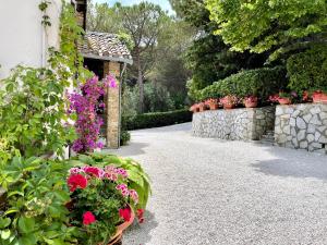 um jardim com flores em vasos e uma parede de pedra em La Panoramica Gubbio - Maison de Charme - Casette e appartamenti self catering per vacanze meravigliose! em Gubbio