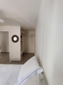 Dormitorio blanco con cama y pared en Precioso apartamento de 2 habitaciones recién reformado en Benidorm en Benidorm