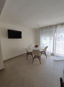 comedor con mesa blanca y sillas en Precioso apartamento de 2 habitaciones recién reformado en Benidorm en Benidorm