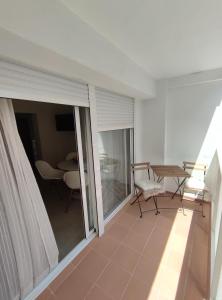 Habitación con balcón con mesa y sillas. en Precioso apartamento de 2 habitaciones recién reformado en Benidorm en Benidorm