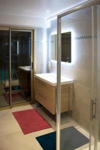 ein Bad mit einem Waschbecken und einem Spiegel in der Unterkunft Appartement rénové, terrasse vue mer in Cagnes-sur-Mer