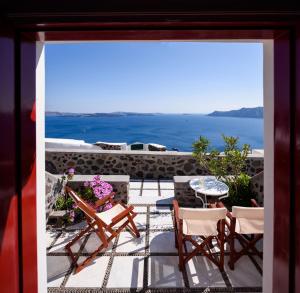 vista su un patio con sedie e tavolo di Nikos Villas a Oia