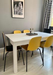 a white dining room table with yellow chairs at Bishy Road Retreat in York