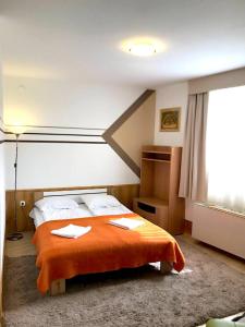 ハイドゥソボスローにあるART Édenのベッドルーム1室(オレンジ色の毛布付きのベッド1台付)
