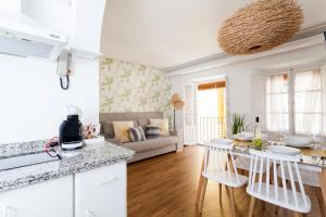 biała kuchnia i salon z kanapą w obiekcie Green-Apartments San Francisco w Sewilli