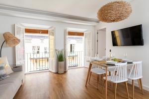 salon ze stołem i kanapą w obiekcie Green-Apartments San Francisco w Sewilli