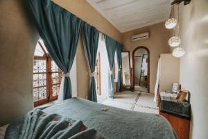 - une chambre avec un lit doté de rideaux bleus et une fenêtre dans l'établissement Dar Nour el Houda, à Marrakech