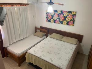 - une chambre avec 2 lits et un tableau mural dans l'établissement Apartamento Village do Bosque - a 200 metros da praia, à Porto Seguro