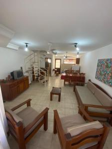 Elle comprend un grand salon doté d'un mobilier en bois. dans l'établissement Apartamento Village do Bosque - a 200 metros da praia, à Porto Seguro