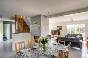 una sala da pranzo e un soggiorno con tavolo e sedie di La Baie Blanche - Maison contemporaine à Saint-Cast-Le-Guildo a Saint-Cast-le-Guildo