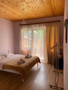 a bedroom with a bed and a large window at WATERFALL in Stepantsminda