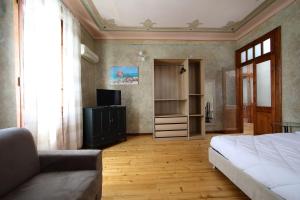 a bedroom with a bed and a tv and a couch at Appartamento liberty con area giochi in Udine